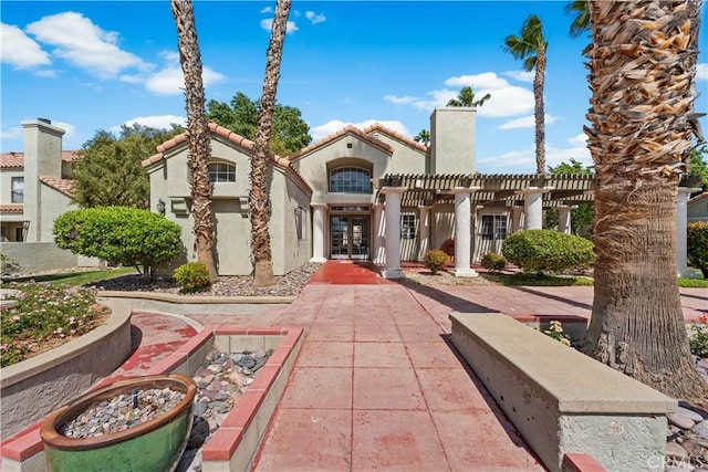 37940 42nd St E Unit 115, Palmdale, CA 93552 - view of front of house with french doors, stucco siding, and a pergola
