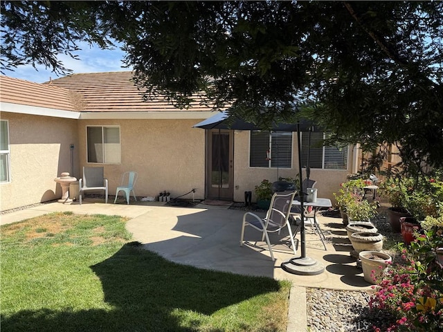 1438 Tumbleweed Ct, Oakdale, CA 95361 - rear view of house featuring stucco siding, a patio area, a lawn, and a tile roof