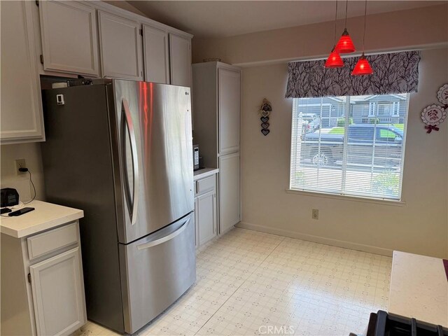 1438 Tumbleweed Ct, Oakdale, CA 95361 - kitchen featuring freestanding refrigerator, light flooring, light countertops, hanging light fixtures, and baseboards