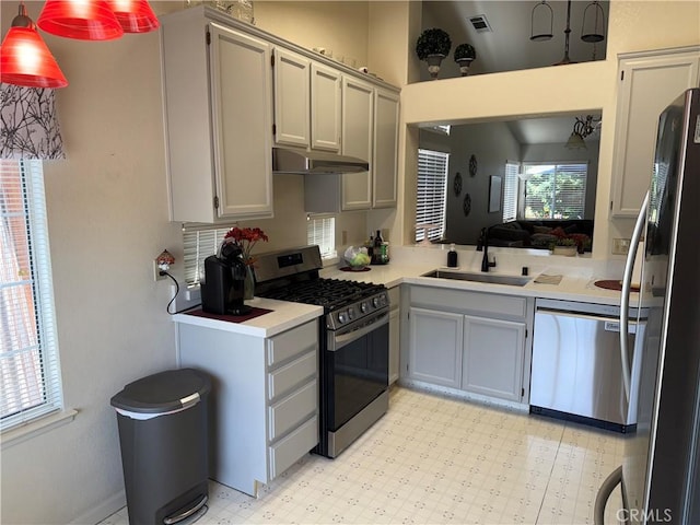 1438 Tumbleweed Ct, Oakdale, CA 95361 - kitchen with appliances with stainless steel finishes, under cabinet range hood, a sink, light countertops, and light flooring