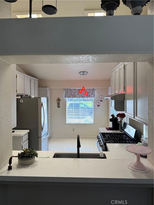 1438 Tumbleweed Ct, Oakdale, CA 95361 - kitchen with appliances with stainless steel finishes, a sink, light countertops, and decorative light fixtures