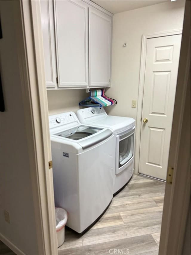 1438 Tumbleweed Ct, Oakdale, CA 95361 - laundry area featuring washer and clothes dryer, cabinet space, and light wood finished floors