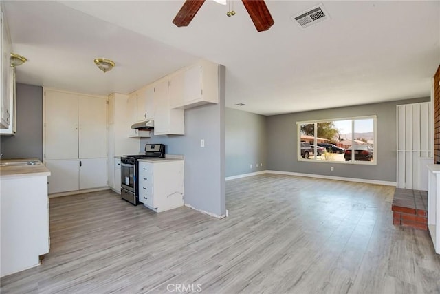 13388 Mohawk Rd, Apple Valley, CA 92308 - kitchen with stainless steel gas stove, light countertops, under cabinet range hood, a sink, and a ceiling fan