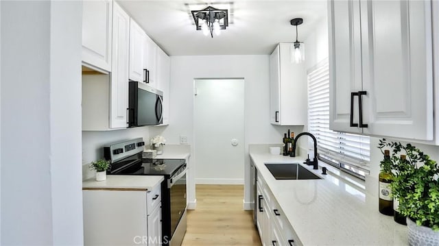23331 Caminito Basilio Unit 348, Laguna Hills, CA 92653 - kitchen with appliances with stainless steel finishes, a sink, white cabinetry, light wood-style floors, and baseboards