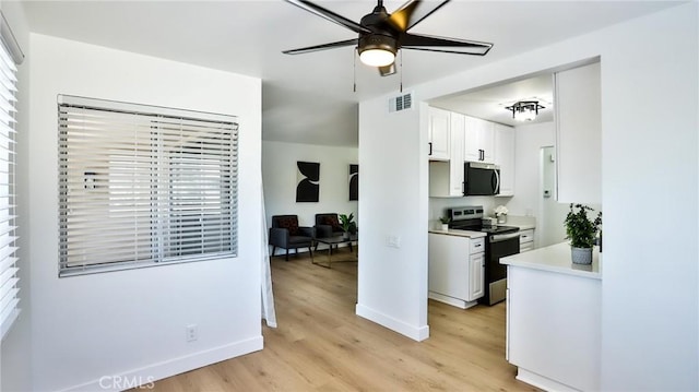 23331 Caminito Basilio Unit 348, Laguna Hills, CA 92653 - kitchen with appliances with stainless steel finishes, light wood finished floors, ceiling fan, light countertops, and baseboards