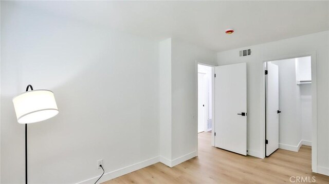 23331 Caminito Basilio Unit 348, Laguna Hills, CA 92653 - unfurnished bedroom featuring light wood-style floors, baseboards, a spacious closet, and a closet