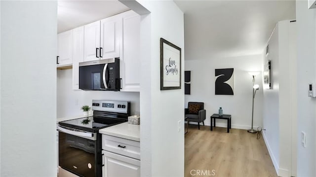 23331 Caminito Basilio Unit 348, Laguna Hills, CA 92653 - kitchen featuring stainless steel appliances, light wood finished floors, light countertops, white cabinets, and baseboards