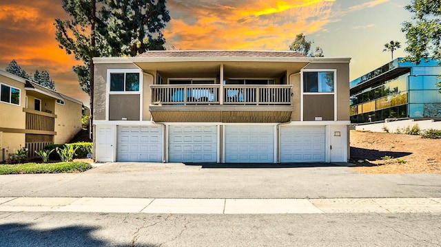 23331 Caminito Basilio Unit 348, Laguna Hills, CA 92653 - view of front facade featuring a balcony, an attached garage, driveway, and stucco siding