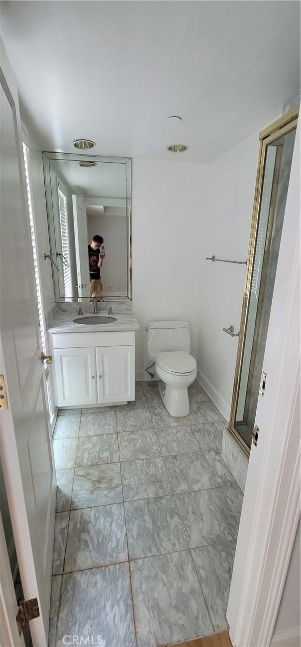448 N Oakhurst Dr Unit 1, Beverly Hills, CA 90210 - full bathroom featuring toilet, vanity, a shower stall, baseboards, and marble finish floors