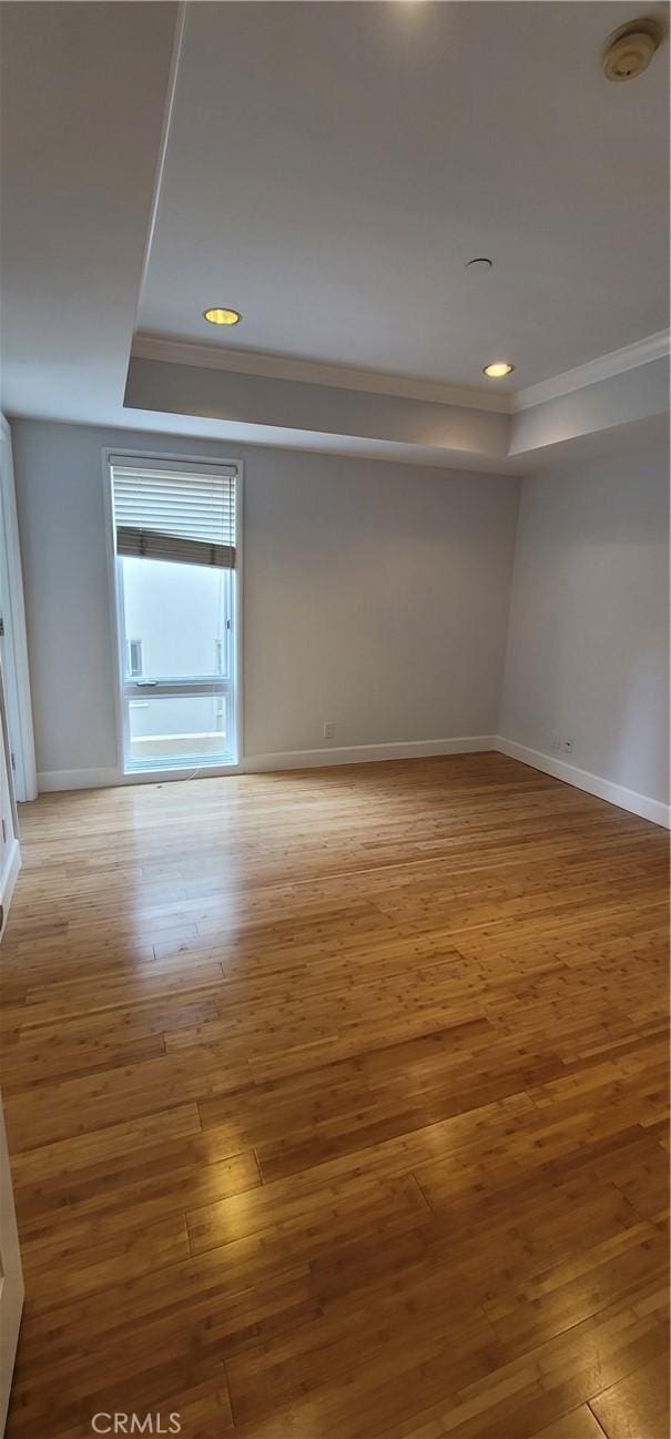 448 N Oakhurst Dr Unit 1, Beverly Hills, CA 90210 - spare room with a raised ceiling, a smoke detector, baseboards, wood-type flooring, and crown molding