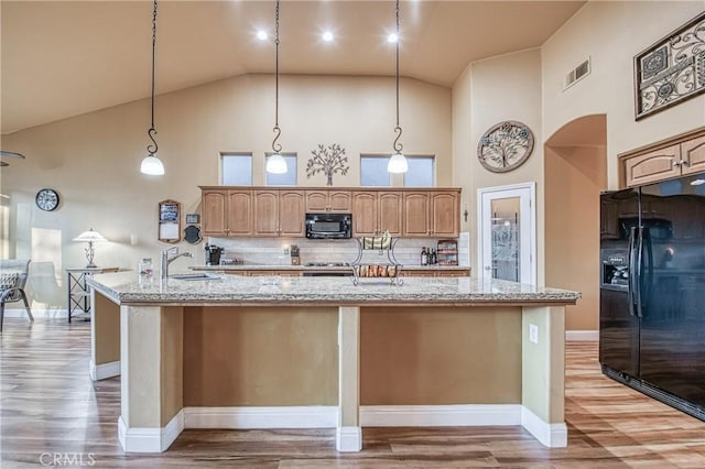 2737 Sussex Ave, Clovis, CA 93611 - kitchen featuring black appliances, high vaulted ceiling, a spacious island, a sink, and light wood-style floors
