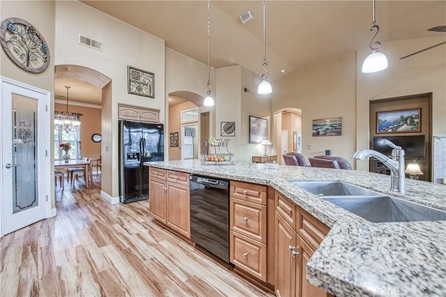 2737 Sussex Ave, Clovis, CA 93611 - kitchen with black appliances, a sink, arched walkways, high vaulted ceiling, and light stone counters