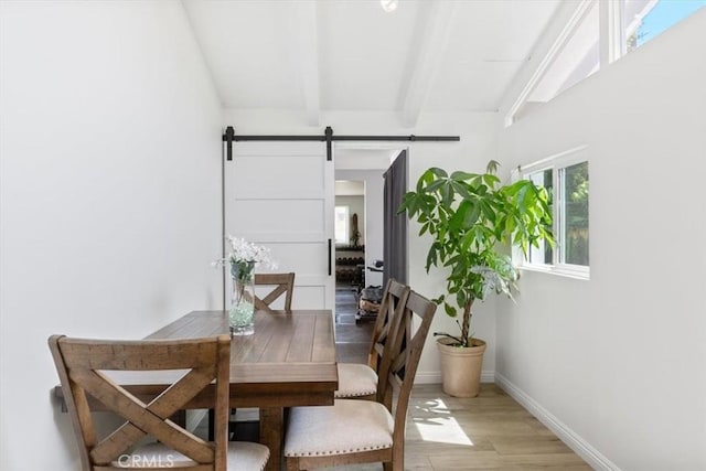 19842 Gilmore St, Woodland Hills, CA 91367 - dining space featuring beam ceiling, a barn door, light wood finished floors, and baseboards