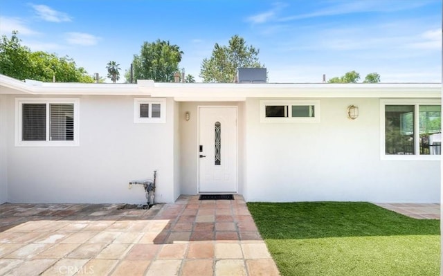 19842 Gilmore St, Woodland Hills, CA 91367 - view of exterior entry with stucco siding and a lawn