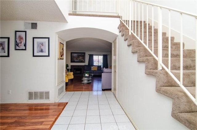 28948 Marilyn Dr, Canyon Country, CA 91387 - tiled foyer entrance with arched walkways, baseboards, stairs, and a fireplace
