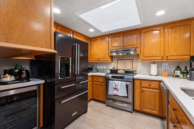 270 Cagney Ln Unit 315, Newport Beach, CA 92663 - kitchen featuring stainless steel appliances, beverage cooler, under cabinet range hood, brown cabinets, and light countertops