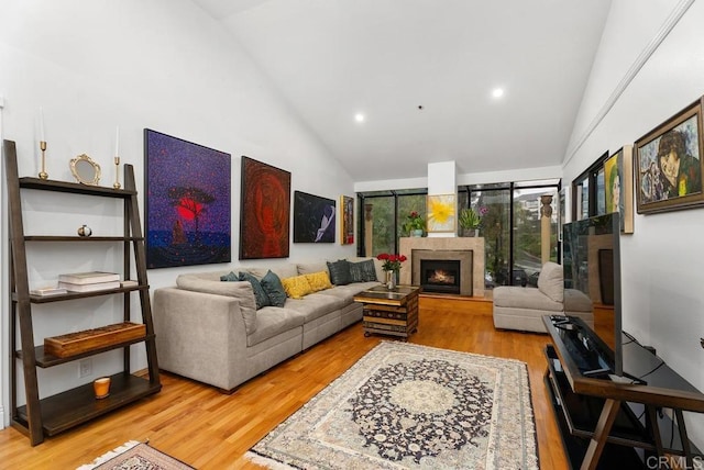 270 Cagney Ln Unit 315, Newport Beach, CA 92663 - living area featuring high vaulted ceiling, wood finished floors, a warm lit fireplace, and recessed lighting