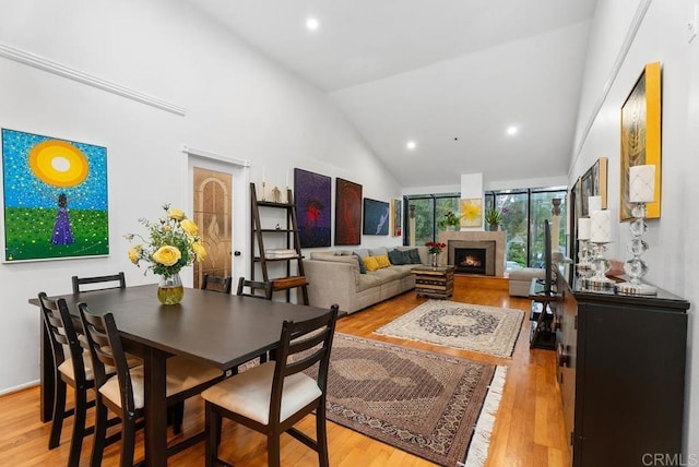 270 Cagney Ln Unit 315, Newport Beach, CA 92663 - dining room featuring light wood-type flooring, high vaulted ceiling, a lit fireplace, and recessed lighting
