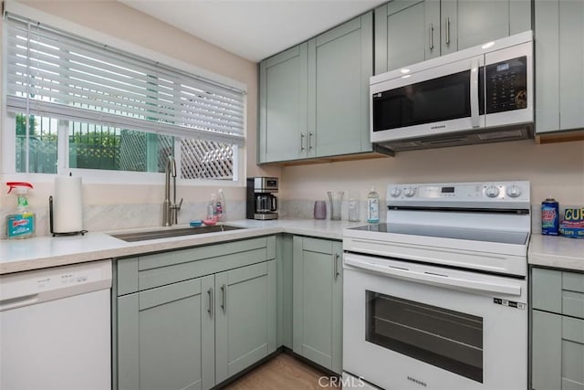 3404 Los Mochis Way, Oceanside, CA 92056 - kitchen with white appliances, a sink, light countertops, and light wood finished floors