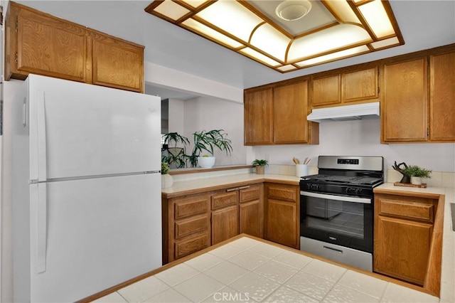 949 W Imperial Blvd Unit 14C, La Habra, CA 90631 - kitchen with freestanding refrigerator, gas range, under cabinet range hood, and brown cabinetry