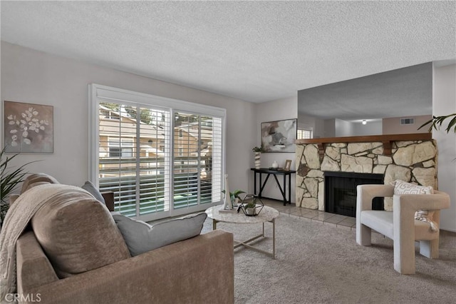 949 W Imperial Blvd Unit 14C, La Habra, CA 90631 - living room with a textured ceiling, a stone fireplace, and carpet flooring