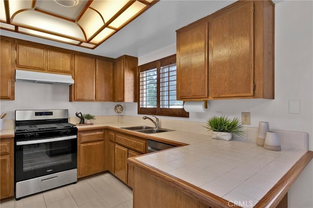 949 W Imperial Blvd Unit 14C, La Habra, CA 90631 - kitchen with stainless steel appliances, under cabinet range hood, brown cabinetry, tile countertops, and a peninsula