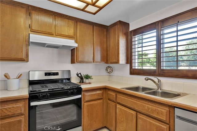 949 W Imperial Blvd Unit 14C, La Habra, CA 90631 - kitchen with appliances with stainless steel finishes, under cabinet range hood, tile countertops, and brown cabinets