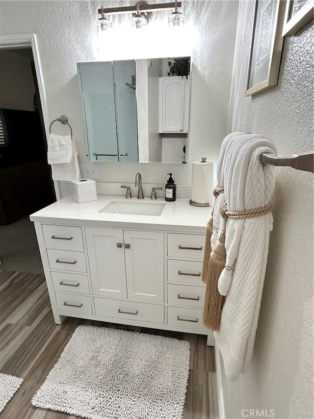 41410 Juniper St Unit 2012, Murrieta, CA 92562 - bathroom with a textured wall, wood finished floors, and vanity