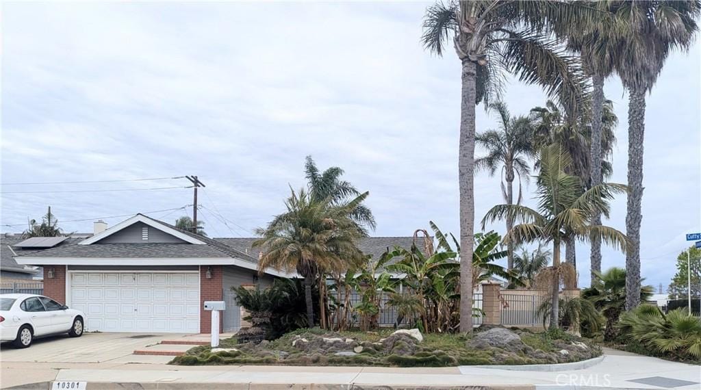10301 Cutty Sark Dr, Huntington Beach, CA 92646 - view of front of house with a garage, driveway, brick siding, and a shingled roof