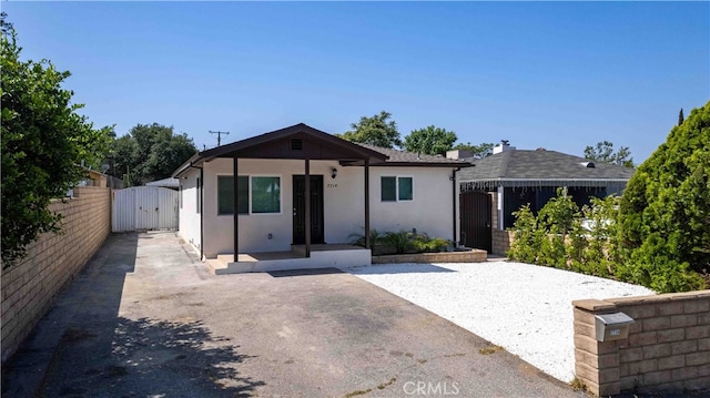 7714 Kyle St, Tujunga, CA 91042 - view of front facade featuring a gate, stucco siding, a storage unit, and a patio