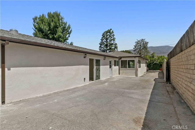7714 Kyle St, Tujunga, CA 91042 - back of property featuring stucco siding, a patio area, and a shingled roof