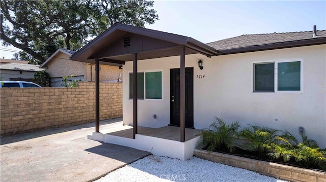 7714 Kyle St, Tujunga, CA 91042 - doorway to property featuring stucco siding and a shingled roof
