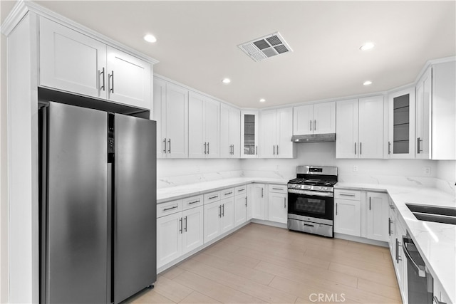 7714 Kyle St, Tujunga, CA 91042 - kitchen with appliances with stainless steel finishes, under cabinet range hood, white cabinetry, a sink, and recessed lighting