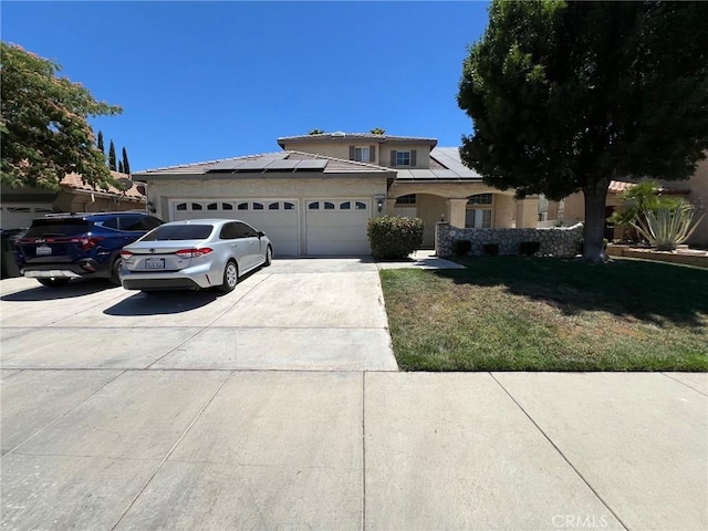 12413 Redrock Rd, Victorville, CA 92392 - view of front facade with an attached garage, concrete driveway, roof mounted solar panels, a front yard, and stucco siding