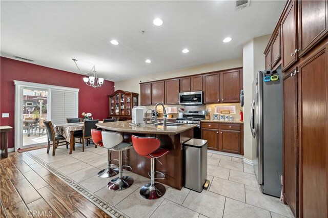 37814 Veranda Way, Murrieta, CA 92563 - kitchen featuring appliances with stainless steel finishes, a chandelier, a breakfast bar, an island with sink, and recessed lighting
