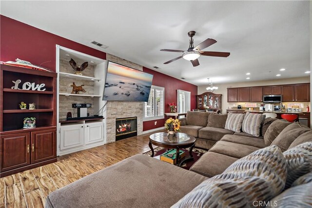 37814 Veranda Way, Murrieta, CA 92563 - living room featuring a ceiling fan, light wood finished floors, a fireplace, recessed lighting, and a chandelier