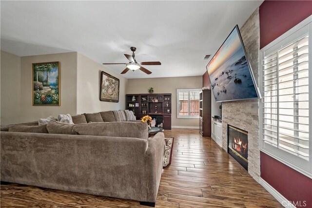 37814 Veranda Way, Murrieta, CA 92563 - living area with a fireplace, a ceiling fan, baseboards, and dark wood-type flooring