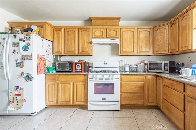 14752 Grafton Ln, Helendale, CA 92342 - kitchen featuring white appliances, under cabinet range hood, light tile patterned floors, and brown cabinetry