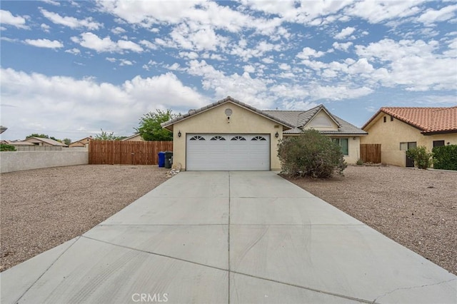 14752 Grafton Ln, Helendale, CA 92342 - view of front facade featuring stucco siding, a garage, driveway, and a tile roof
