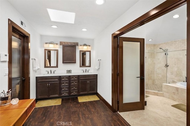 27121 Shenandoah Dr, Laguna Hills, CA 92653 - bathroom with a skylight, a stall shower, double vanity, a bath, and recessed lighting