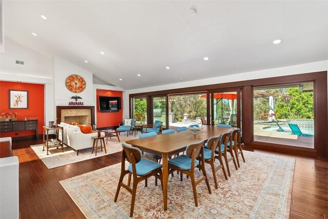 27121 Shenandoah Dr, Laguna Hills, CA 92653 - dining space featuring a lit fireplace, hardwood / wood-style floors, recessed lighting, and high vaulted ceiling