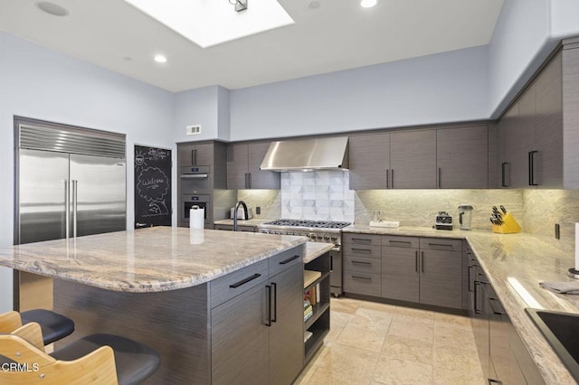 815 Mandalay Beach Rd, Oxnard, CA 93035 - kitchen with wall chimney range hood, a kitchen bar, high quality appliances, backsplash, and modern cabinets