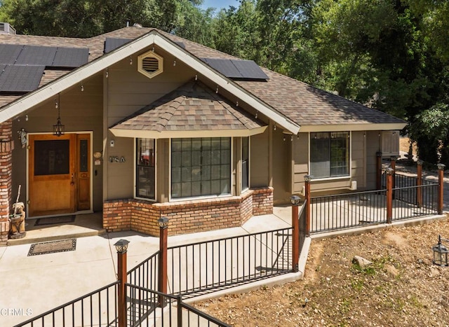 51793 Quail Ridge Rd, Oakhurst, CA 93644 - view of front of home featuring roof with shingles, solar panels, and brick siding