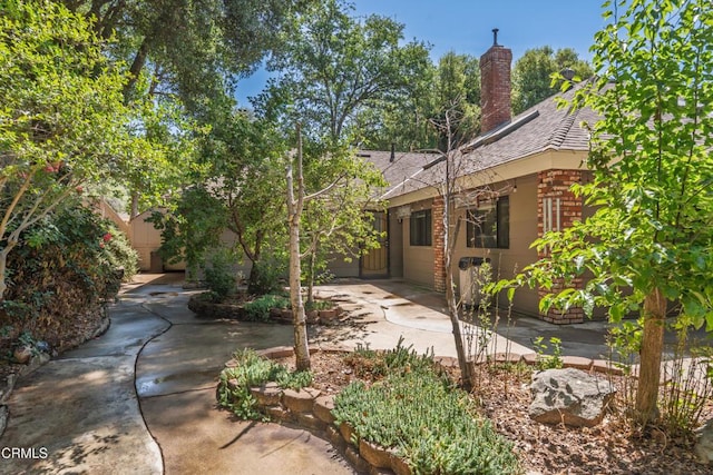 51793 Quail Ridge Rd, Oakhurst, CA 93644 - rear view of property featuring a patio area, a chimney, roof with shingles, and brick siding