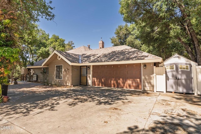 51793 Quail Ridge Rd, Oakhurst, CA 93644 - single story home featuring a storage unit, an attached garage, a chimney, concrete driveway, and a shingled roof