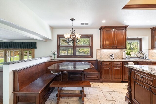 469 Grinnel Ct, Simi Valley, CA 93065 - kitchen with breakfast area, tasteful backsplash, a sink, a chandelier, and light stone counters