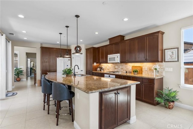 905 Romneya Ln, Santa Maria, CA 93455 - kitchen with white appliances, a sink, tasteful backsplash, light tile patterned flooring, and a breakfast bar area