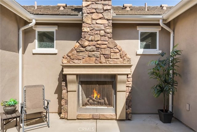 905 Romneya Ln, Santa Maria, CA 93455 - detailed view of a lit fireplace, gutters, a downspout, stucco siding, and a chimney