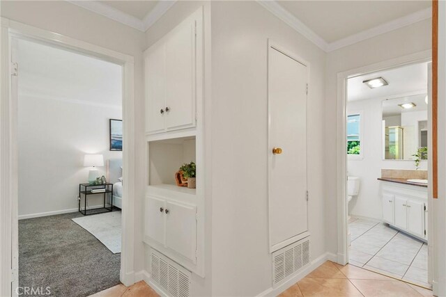 1525 E Baldwin Ave, Orange, CA 92865 - hall with ornamental molding, light tile patterned floors, baseboards, and light colored carpet