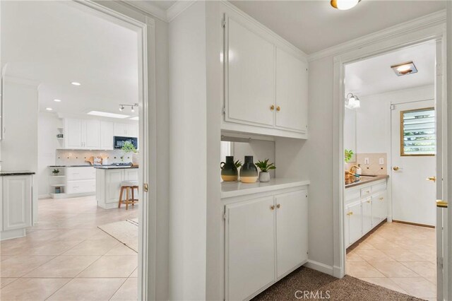 1525 E Baldwin Ave, Orange, CA 92865 - bar area featuring black microwave, tasteful backsplash, light tile patterned floors, ornamental molding, and recessed lighting